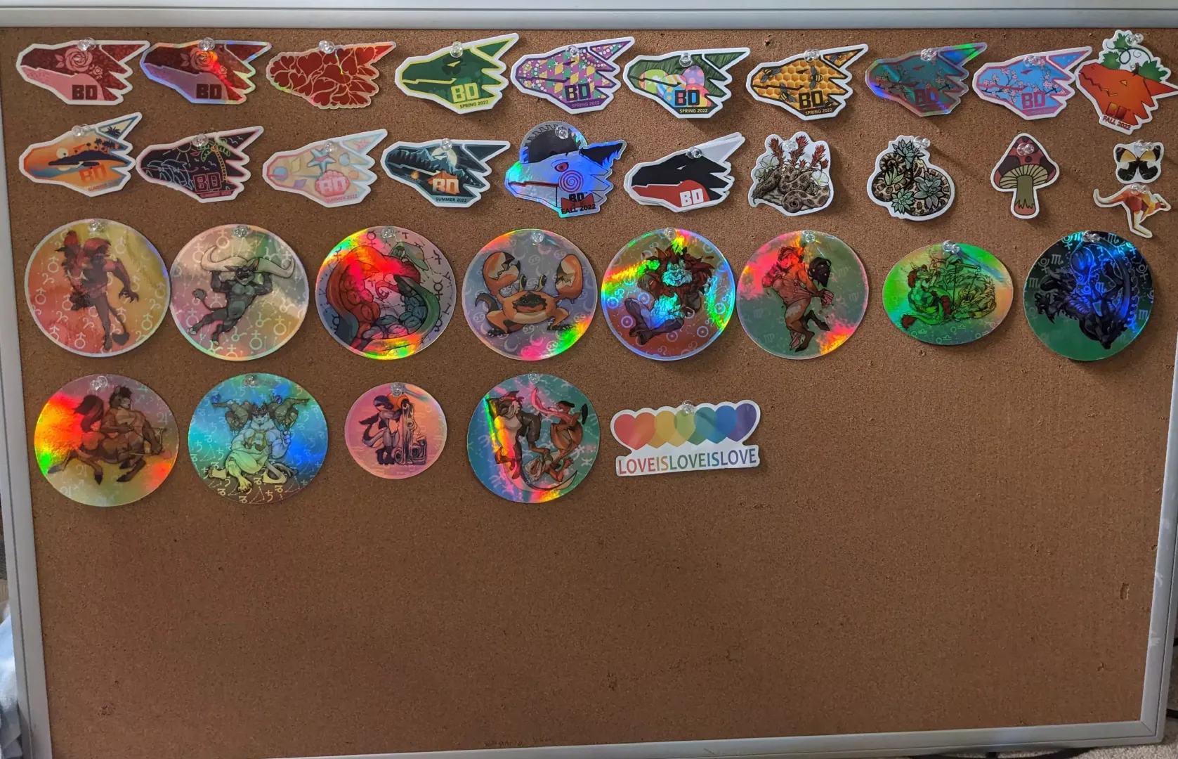 don't like sticking stickers so I pin them. Just got a nice board for them at the thrift store so I have space to display all of them :3.